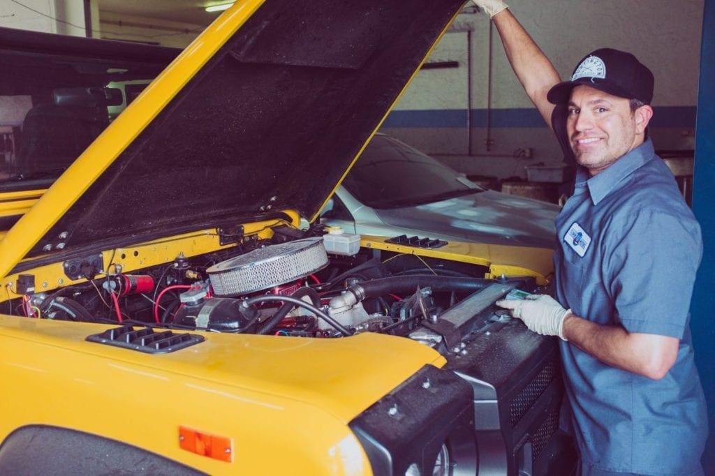 mechanic standing by open truck hood