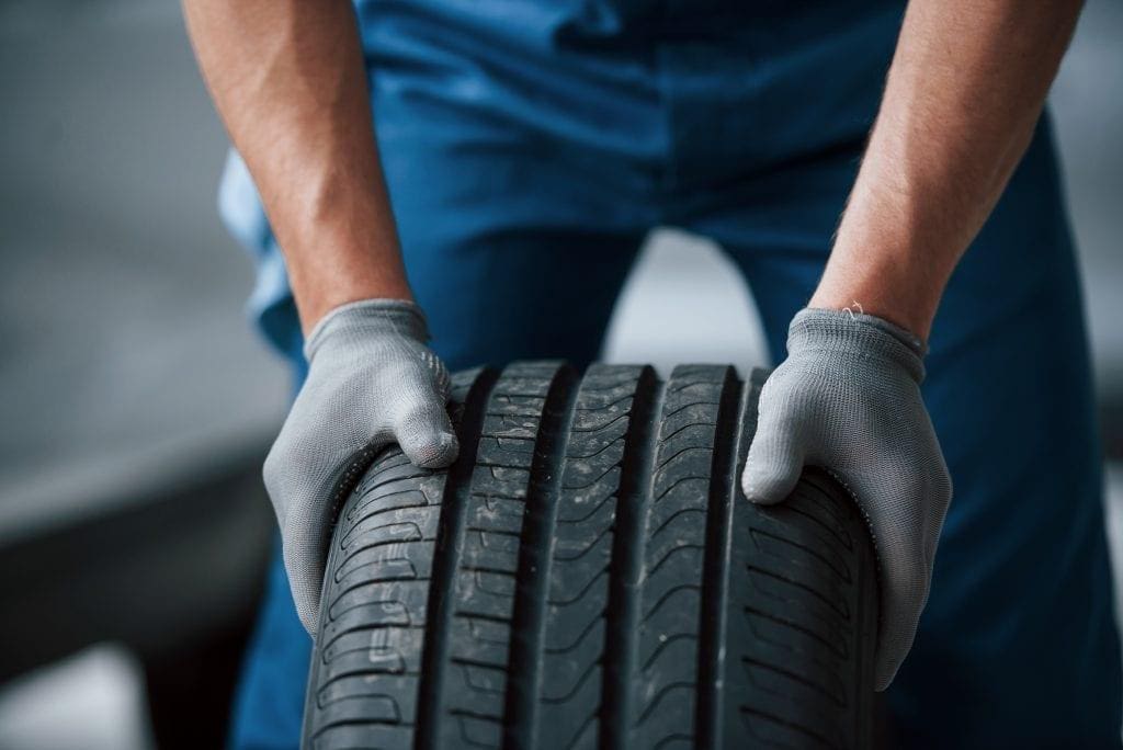 man prepares a new tire for installation