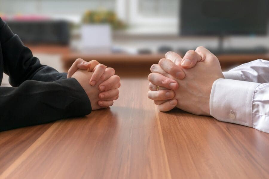 Two people sitting down to negotiate