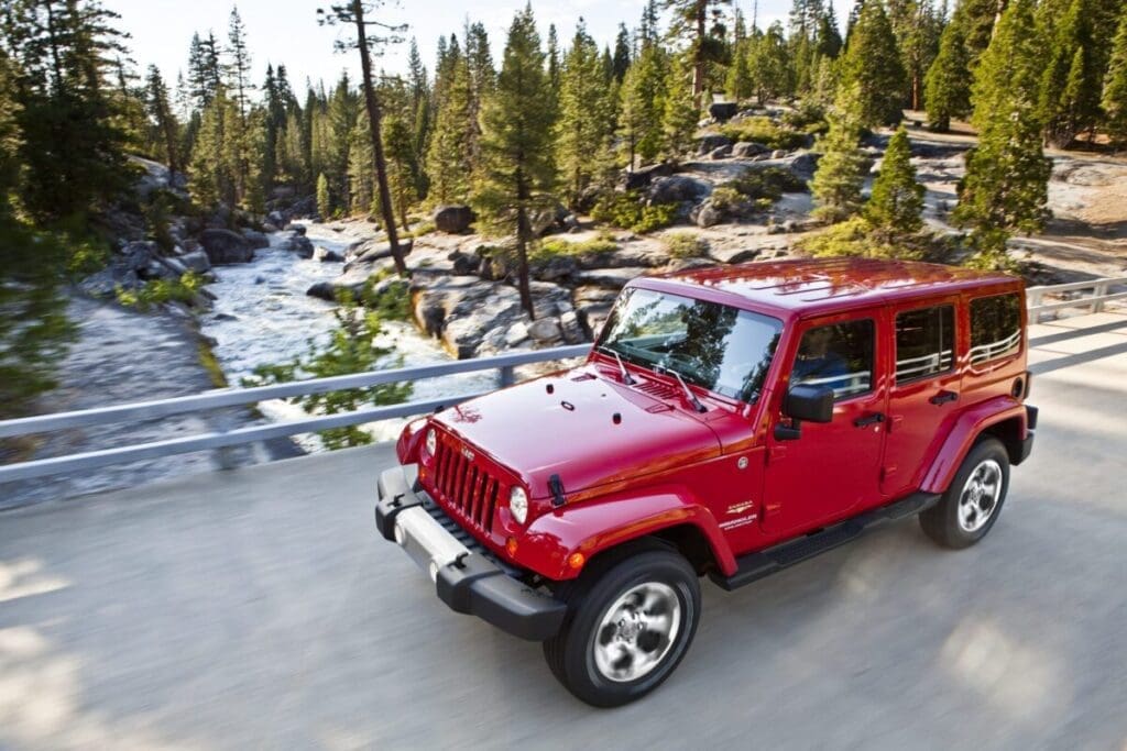 2015 Jeep Wrangler Unlimited Sahara driving across a backcountry bridge