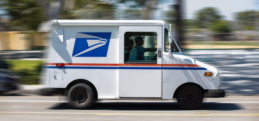 USPS mail truck driving on the street